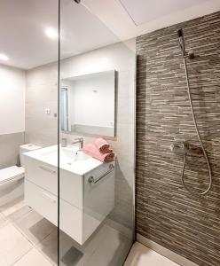 a bathroom with a sink and a glass shower at Paradise Palms I Deluxe, incl. Welcome Package in Corralejo