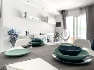 a dining room table with green plates and wine glasses at Paradise Palms I Deluxe, incl. Welcome Package in Corralejo