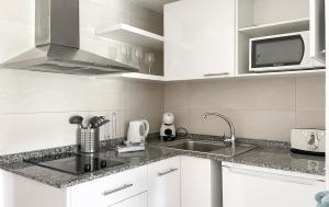 a white kitchen with a sink and a microwave at Paradise Palms I Deluxe, incl. Welcome Package in Corralejo