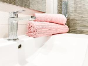 a bathroom with pink towels sitting on a sink at Paradise Palms I Deluxe, incl. Welcome Package in Corralejo