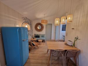 a kitchen with a blue refrigerator and a table at La p'tite cabane - Maisonnette Carnon Plage in Carnon-Plage