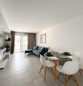 a living room with a table and white chairs at Paradise Palms I Deluxe, incl. Welcome Package in Corralejo