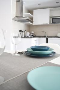a kitchen with a table with plates and a wine glass at Paradise Palms I Deluxe, incl. Welcome Package in Corralejo
