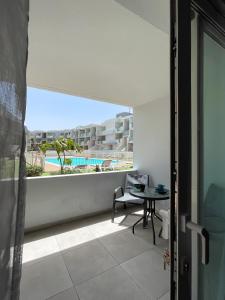 a balcony with a table and a view of a pool at Paradise Palms I Deluxe, incl. Welcome Package in Corralejo