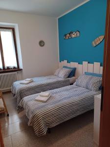 2 camas en una habitación con paredes azules en Appartamento A 2 passi dal Lago Idro Lake en Bondone