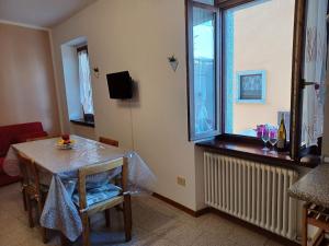 a living room with a table and a window at Appartamento A 2 passi dal Lago Idro Lake in Bondone