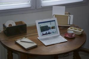 Gîte La Terrasse Du Verger في كاركفو: يوجد جهاز كمبيوتر محمول على رأس طاولة خشبية