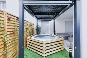 d'un bain à remous dans une arrière-cour avec une clôture. dans l'établissement Confort Familial/Professionnel aux Portes de Paris, à Bezons