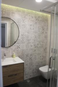 a bathroom with a sink and a toilet and a mirror at Encosta's Beach in Paço de Arcos