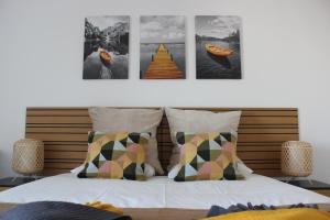 a bedroom with a bed with four pictures on the wall at Encosta's Beach in Paço de Arcos