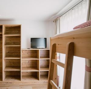 a bedroom with a bunk bed and a tv at Nedererhof - Zimmer Edelweiß mit Gemeinschaftsküche in Schmirn