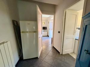 una cucina con frigorifero e una porta aperta di Il giardino degli ulivi a Levanto Altre 8 foto