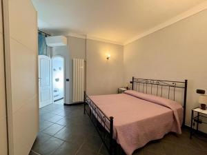 una camera con un letto e una coperta rosa di Il giardino degli ulivi a Levanto