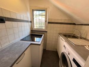 una piccola cucina con lavandino e lavatrice di Il giardino degli ulivi a Levanto