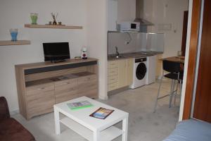 uma sala de estar com uma pequena cozinha com uma mesa em Estudio Fibes-Palacio em Sevilha