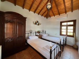 Villa Pigadi في شاطئ ميغالي أموس: غرفة نوم بسريرين وسقف خشبي
