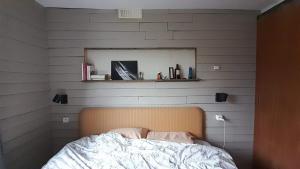 Schlafzimmer mit einem Bett und einem Spiegel an der Wand in der Unterkunft Le Petit Cavron in Cavron-Saint-Martin