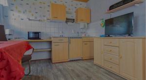 uma grande cozinha com armários de madeira e uma mesa vermelha em Ferienwohnungen Wald und Wasser Fam.Schurat em Feldberg