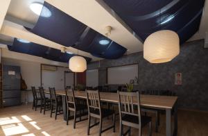 einen Konferenzraum mit einem langen Tisch und Stühlen in der Unterkunft Hostel JAQ takamatsu in Takamatsu