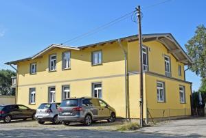 um edifício amarelo com carros estacionados em frente em Strandhaus Goehren em Göhren