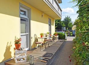 a wooden deck with a table and chairs on a house at Strandhaus Goehren in Göhren