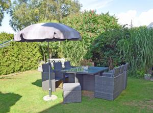 a table and chairs under an umbrella in a yard at Strandhaus Goehren in Göhren