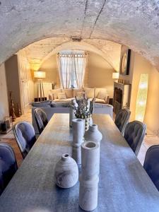 a long table with vases on it in a room at Le Gardien des Anges in Vers Pont du Gard