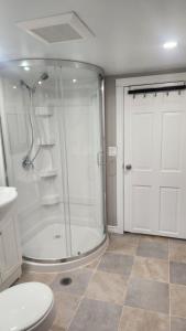 a bathroom with a shower and a toilet and a door at Dieppe Apartment in Dieppe