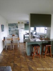 a kitchen and dining room with a table and chairs at Streams Cottage in Bettyʼs Bay