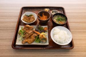 un plateau de nourriture avec de la viande, des légumes et du riz dans l'établissement Hostel JAQ takamatsu, à Takamatsu