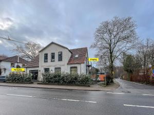 a white house on the side of a street at Moor Feeling Apartments Worpswede in Worpswede