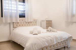 Cama blanca en habitación con ventana en Hadas Villa Spa Yavne'el by Sea N' Rent, en Yavneʼel