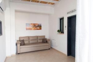 sala de estar con sofá en una pared blanca en Hadas Villa Spa Yavne'el by Sea N' Rent, en Yavneʼel