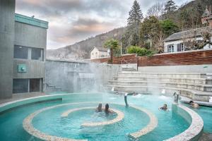 un gruppo di persone in una piscina con cascata di Le Grillon ad Ax-les-Thermes