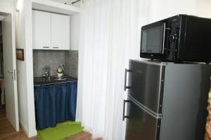 a kitchen with a television on top of a refrigerator at Quattro Canti - residenza Santa Caterina in Palermo