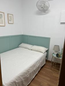 una camera da letto con un letto bianco e una luce sopra di esso di Apartamento Villa Caracol a Cunit