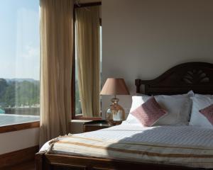 a bedroom with a bed and a large window at THE SHILLONG ADDRESS in Shillong