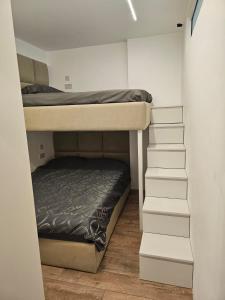 Litera en habitación pequeña con escalera en Dan’s Luxury Apartment, en Durrës