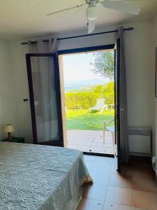 - une chambre avec une porte s'ouvrant sur une terrasse dans l'établissement Villa U Castellu vue mer imprenable, à Coti-Chiavari