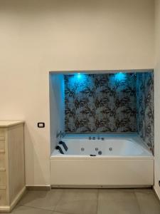 een badkamer met een bad met blauwe verlichting bij La Casa Di Eva in Siracusa