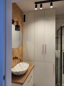 a bathroom with a sink and a mirror at Apartament Jagiełły in Olsztynek