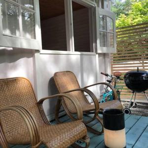 a porch with three chairs and a grill and a bike at Kitakaruizawa Morino Bessou NO8 in Tsumagoi