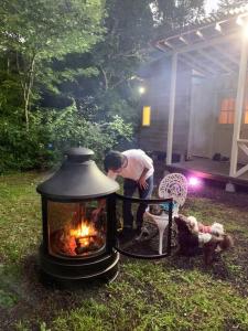Ein Mann steht neben einem Feuer im Garten. in der Unterkunft Kitakaruizawa Morino Bessou NO8 in Tsumagoi