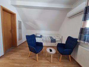 a bedroom with two blue chairs and a bed at Guest House Matej & Mateja in Plitvička Jezera