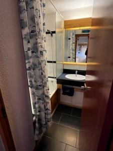 a small bathroom with a sink and a mirror at Appartement Eskival skis aux pieds in Val Thorens