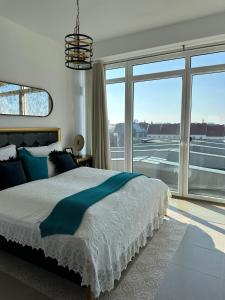 a bedroom with a large bed and a large window at Panorama Apartments Vienna in Vienna