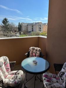 a balcony with two chairs and a table on a balcony at Apartman Happiness in Sombor