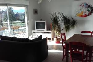 een woonkamer met een tafel en een televisie bij Appart 2 pers, la montagne en ville, avec garage in Oloron-Sainte-Marie