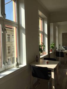 Habitación con 2 ventanas, mesa blanca y sillas. en Newly renovated apt in the heart of Grünerløkka, en Oslo