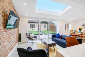 a living room with a brick wall at 6 Bedroom and 4 Bath Bedford House + Private Garden in Ruislip